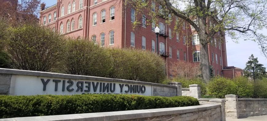 QU Sign and Francis Hall in Spring, West View